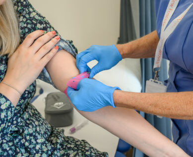 A nurse prepares to take a patient's blood