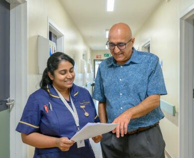 A consultant speaks with a nurse in the hospital corridor