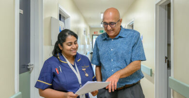 A consultant speaks with a nurse in the hospital corridor