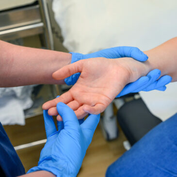 A nurse examines a patient's hand