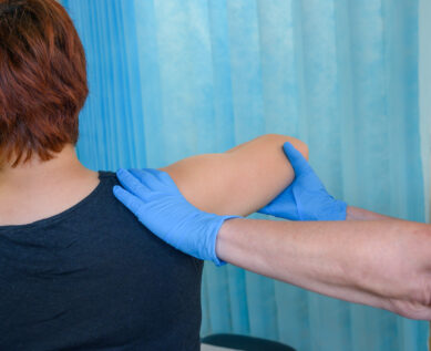 A nurse examines a patient's shoulder