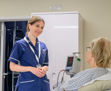 A nurse speaking with a patient in their room