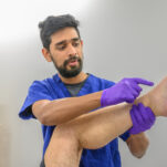 Physiotherapist examining a patient's ankle