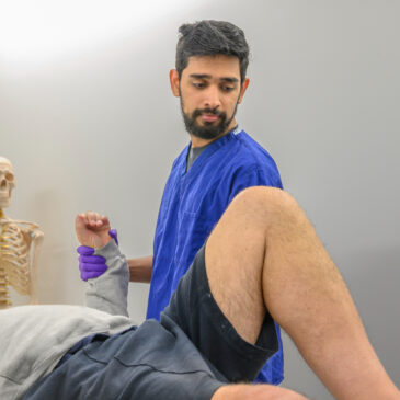 A physiotherapist examines a patient's arm