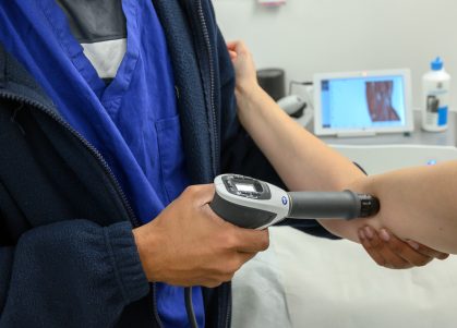 A TENS machine being used on a patient's elbow