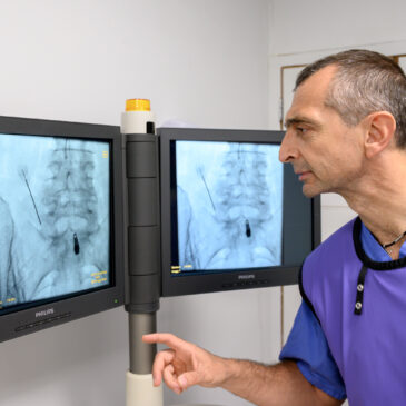 A radiologist looks at X-Rays on a monitor