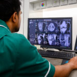 An MRI technician looks at scans on their computer