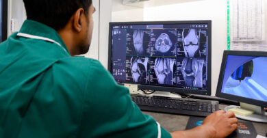 An MRI technician looks at scans on their computer