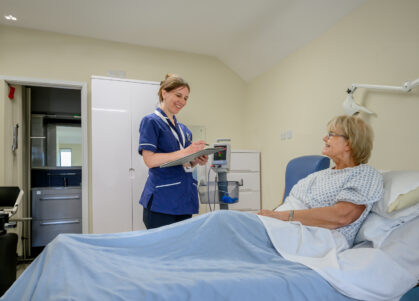 Nurse speaks with a patient in their private room