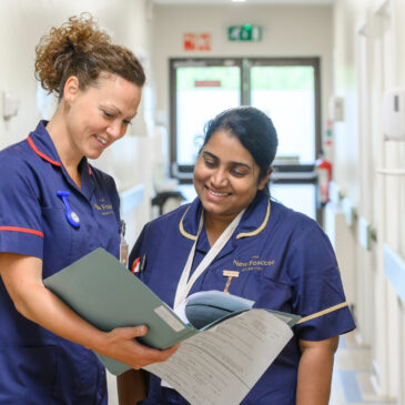 Nurses discuss a patient's notes